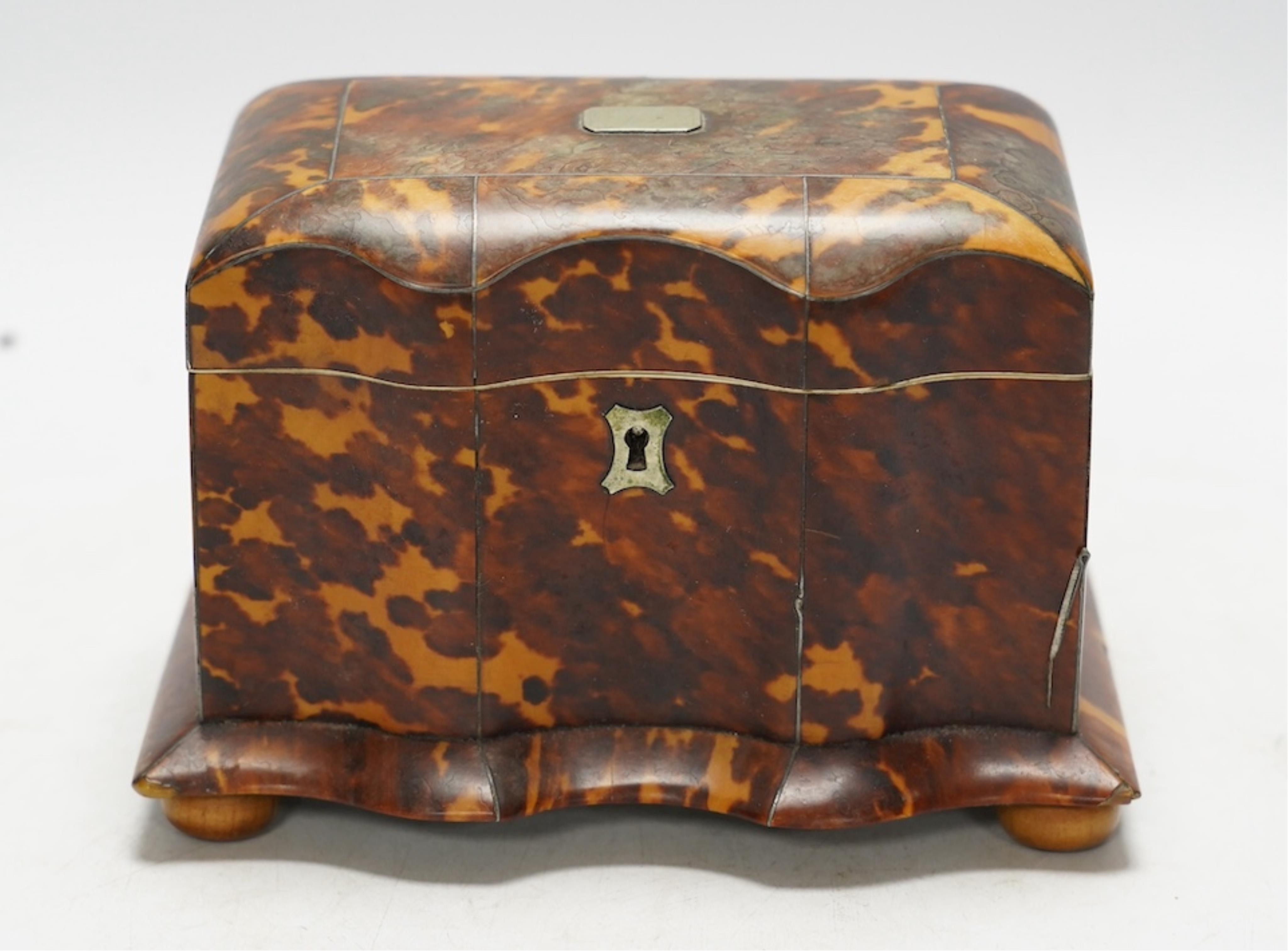 A Regency tortoiseshell tea caddy with inlaid silver and ivory stringing, on later bun feet, 12cm high. CITES Submission reference 64HKMP8J. Condition - poor to fair, lid detached, some repairs needed to stringing